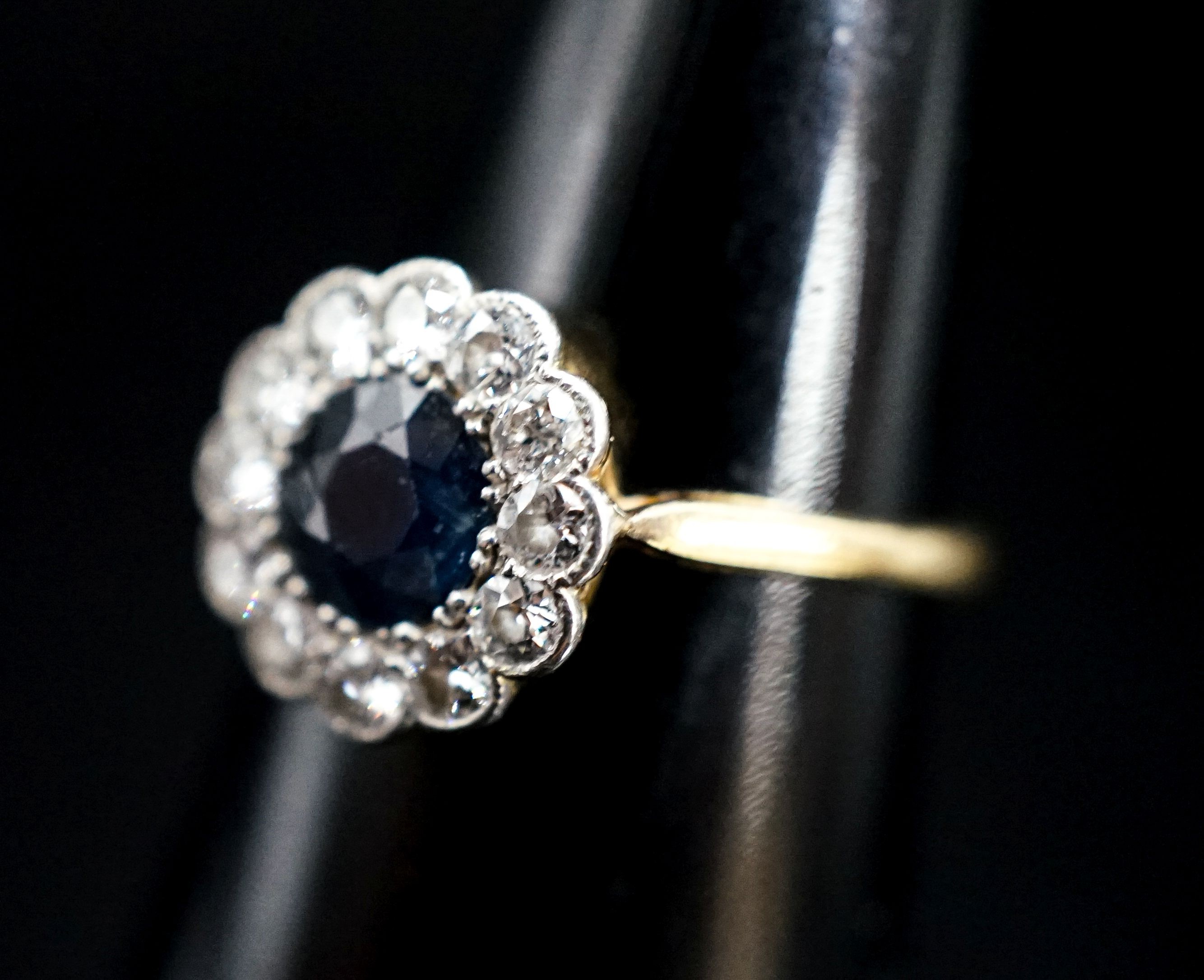 An 18ct, sapphire and diamond set circular cluster ring, size M, gross weight 2.4 grams.